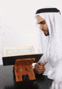 Muslim man reading the Quran, the central Scripture in the doctrines of Islam