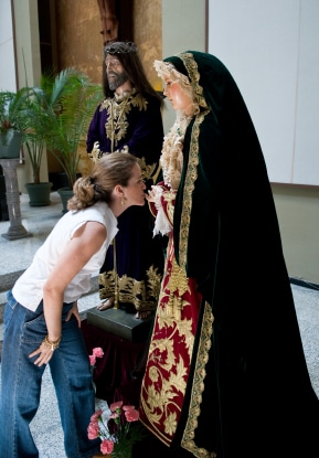 Catholic woman kissing statue of Mary